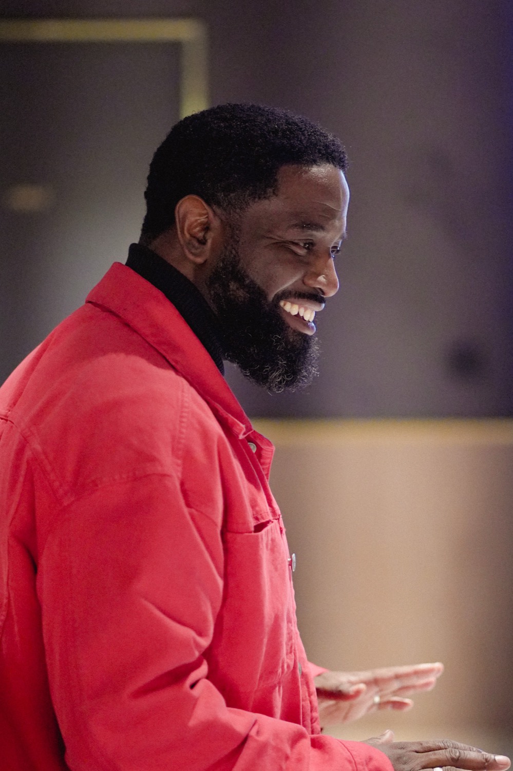 Patrick Sulay en veste rouge, souriant de profil